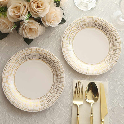 Elegant gold-accented dinner plates on a textured tablecloth with cutlery.