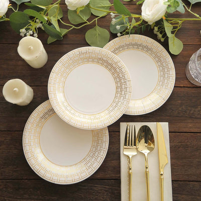 Elegant white plates with gold geometric design, arranged with cutlery and decor.
