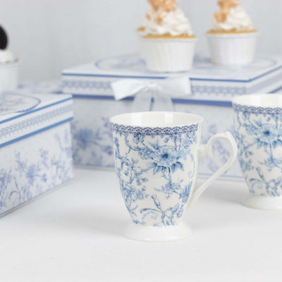 Blue floral patterned porcelain mug with decorative gift boxes in the background.