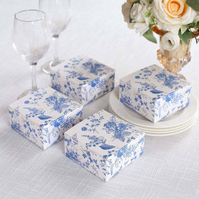 Decorative gift boxes with floral design on a table setting.