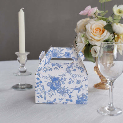 Blue floral takeout box on a table with a candle and flowers.