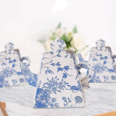 Floral-patterned teapot on a marble surface with blurred background