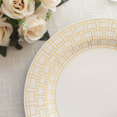 Elegant white plate with gold geometric pattern, styled with soft floral arrangement.