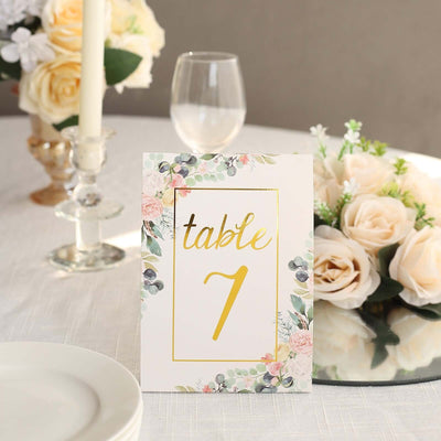 Floral table number sign with gold accents for event decor.