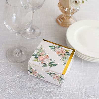 Floral gift box with gold accents on a table setting.