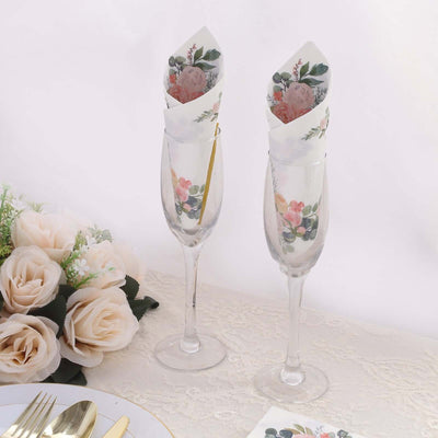 Floral-designed napkins in elegant champagne flutes on a table setting.