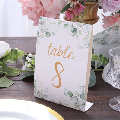 Table number card with floral design, elegant gold script, and green accents.