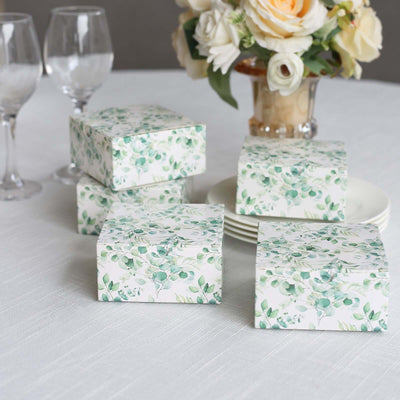 Decorative gift boxes with floral design on a table setting.