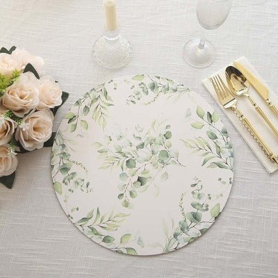 Floral-patterned placemat on a table with candles and cutlery.