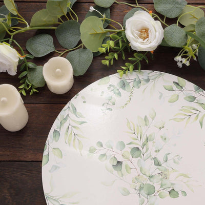 Decorative plate with botanical design surrounded by flowers and candles.