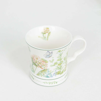 Floral patterned ceramic mug with butterflies and greenery design