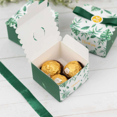 Green gift box with gold chocolates inside, decorated with floral design.