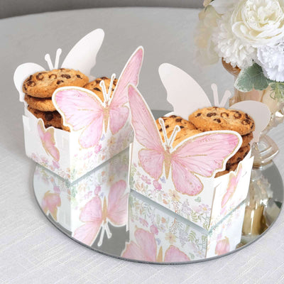 Decorative butterfly cookie boxes filled with chocolate chip cookies on a mirrored surface.