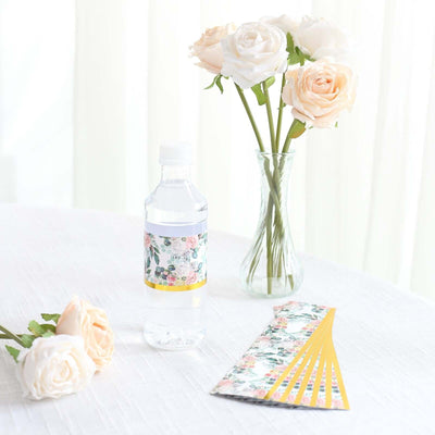 Floral-themed water bottle with decorative labels and roses on a table.