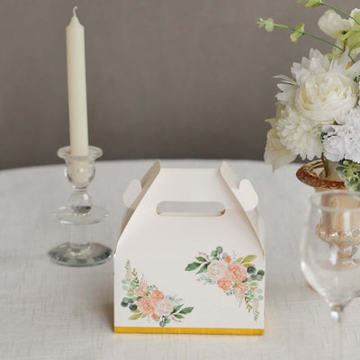 Floral gift box on a table with a candle and flowers in the background.