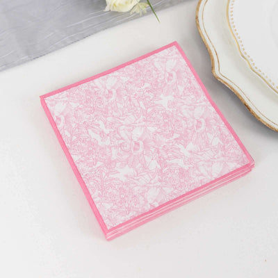Pink floral patterned napkins stacked on a white surface.