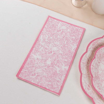 Pink floral-patterned napkin on a light tablecloth.