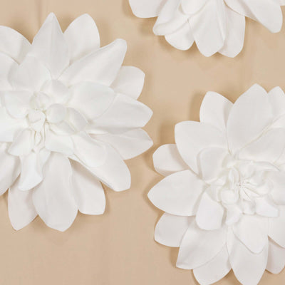 White decorative flower wall art set on a beige background.