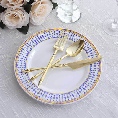 Elegant gold cutlery on a decorative plate with blue pattern and white background.