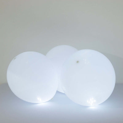 Three glowing white decorative orbs on a plain background