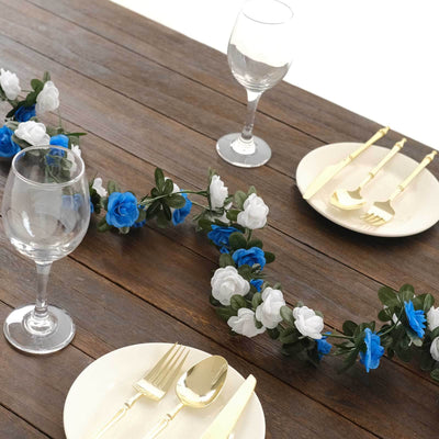 Elegant table setting with floral garland, plates, and glassware.