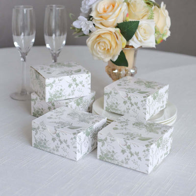 Decorative floral gift boxes on a table with champagne flutes and a bouquet.