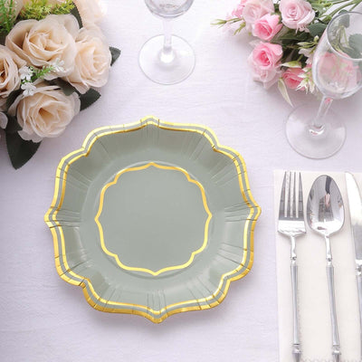 Elegant green paper plate with gold trim on a dining table setting.