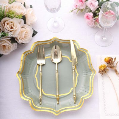 Elegant gold cutlery set on a decorative plate with floral arrangement