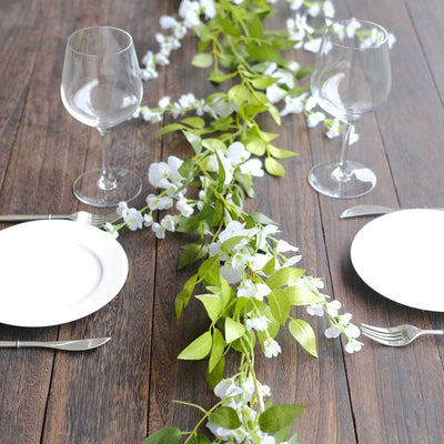 Elegant table setting with glassware and floral centerpiece on wooden surface.