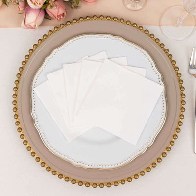 Elegant white napkins on a decorative plate with gold accents.