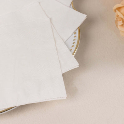White paper napkins stacked on a decorative plate.