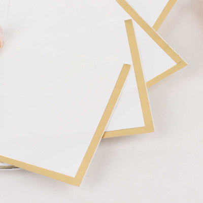 White cards with gold borders arranged neatly on a flat surface.