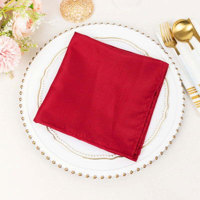 Red silk napkin on an elegant plate setting.