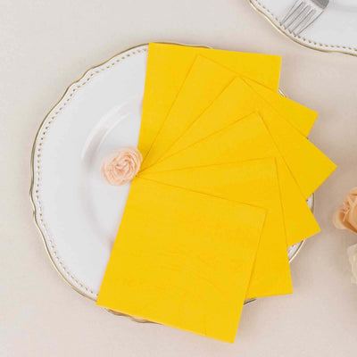 Yellow decorative paper sheets on a white plate with a floral accent.