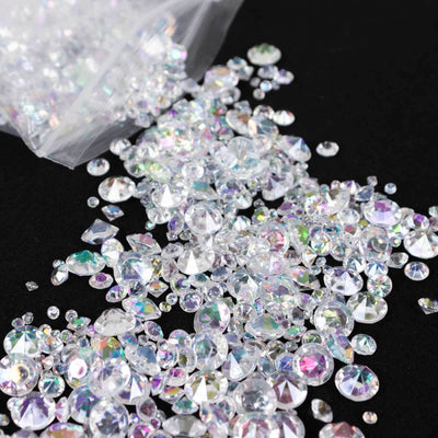 Assorted sparkling acrylic rhinestones in various shapes and sizes on a black background.