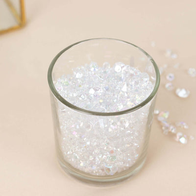 Clear iridescent beads in a glass container on a soft beige surface.