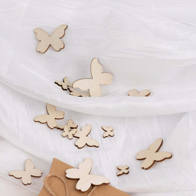Wooden butterfly cutouts on a white fabric backdrop.