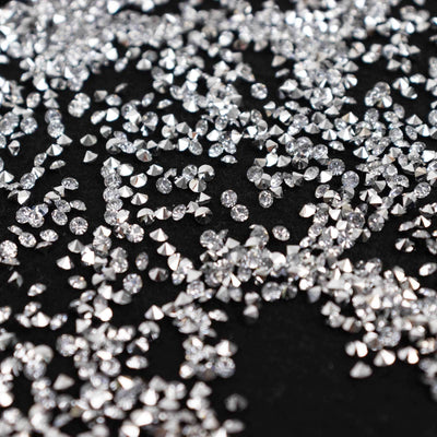 Scattered silver rhinestones on a black background.
