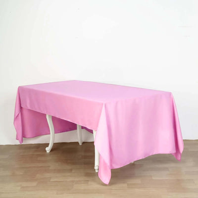 Pink tablecloth draped over a table in a studio setting.