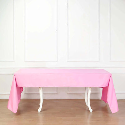 Pink tablecloth draped over a white table in a bright indoor setting.