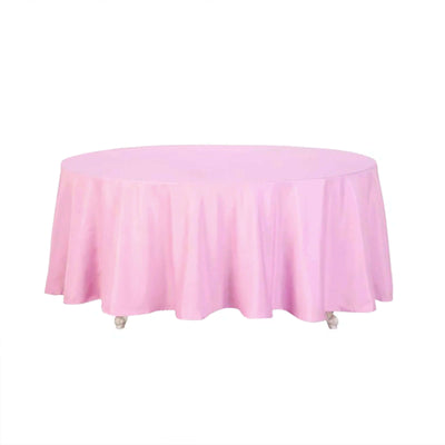 Pink round tablecloth with elegant draping on a white background.