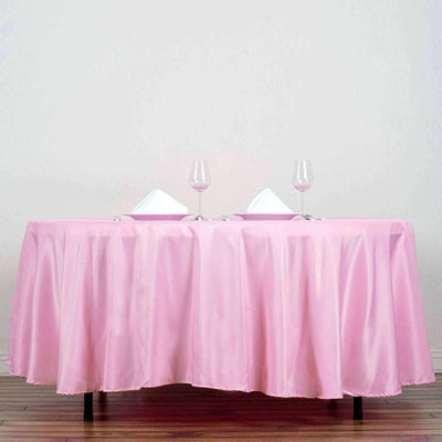 Elegant pink tablecloth draped over a table set for dining.