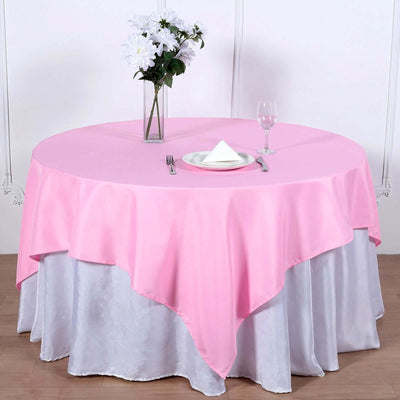 Pink tablecloth draped elegantly over a white table with a vase of flowers.