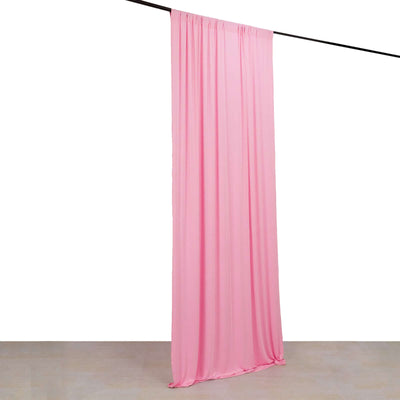 Pink fabric curtain hanging from a rod against a plain background
