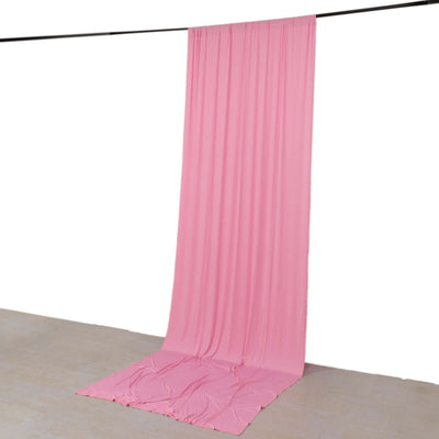 Pink backdrop fabric hanging down in a studio setting.