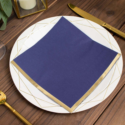 Navy blue napkin with gold trim on a decorative plate