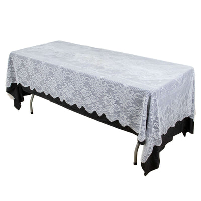 White lace tablecloth draped over a table, showcasing intricate floral patterns.