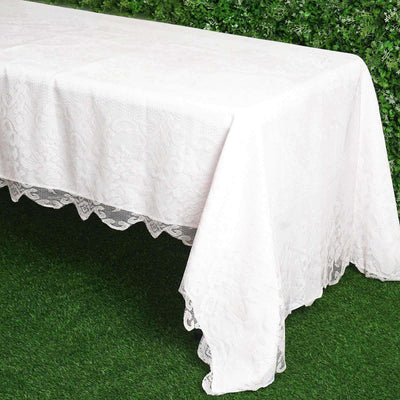 White lace tablecloth draped over a table with a floral design.