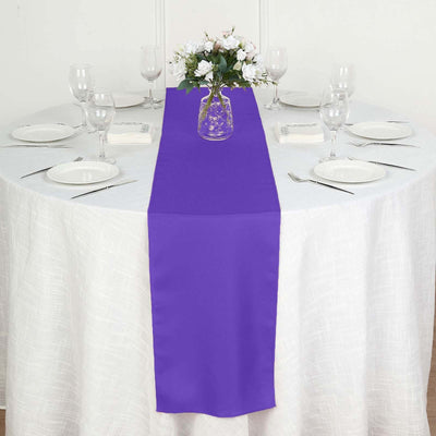 Purple table runner on a round dining table set for a meal.