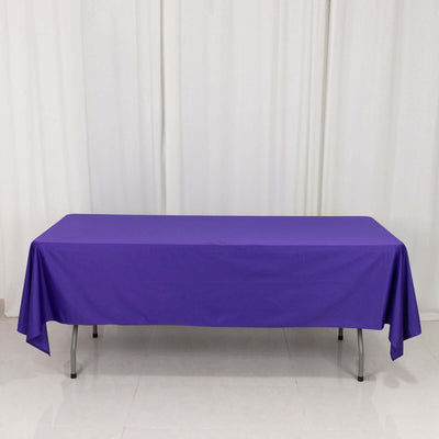 Purple tablecloth on a table against a white backdrop.